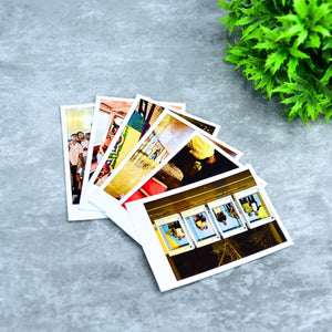 Mayii custom polaroid prints displaying various colorful photo memories on gray surface with green plant