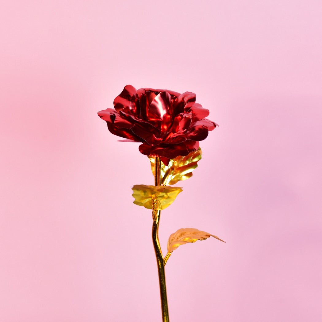 Elegant Valentines Day gifts collection featuring a handcrafted metallic red rose with gold stem and leaves on a pink background